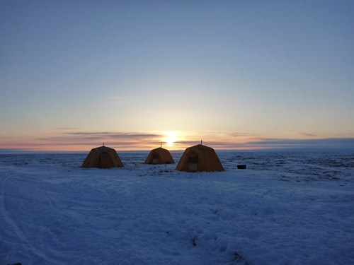 Sunset over Arctic oven tents under clear skies